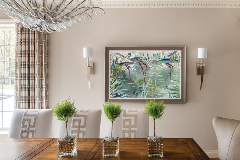 Artwork by Nancy Hammond takes center stage in a dining room with custom chairs adorned with velvet Greek key appliqués.