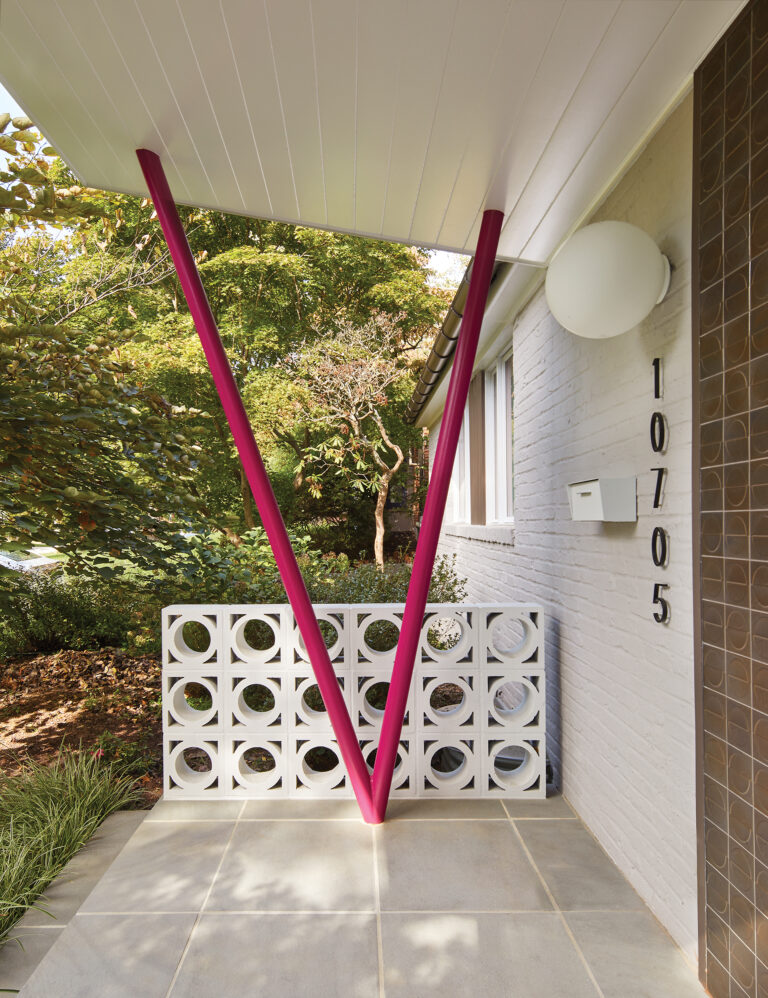 The new entry porch is distinguished by V-shaped steel columns painted pink and breeze blocks, a quintessentially mid-century design element.”