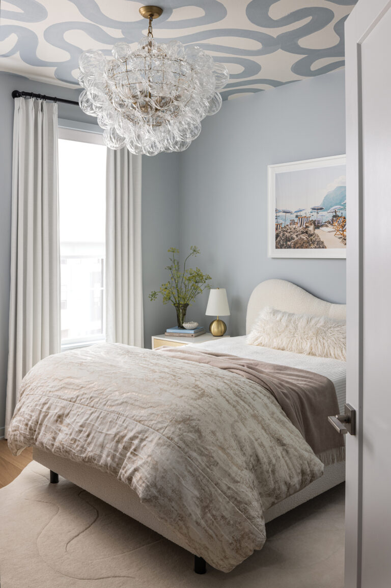 An abstract wallpapered ceiling and sculptural shapes reinforce the cloud-like design of a bedroom. Styling: Limonata Creative.