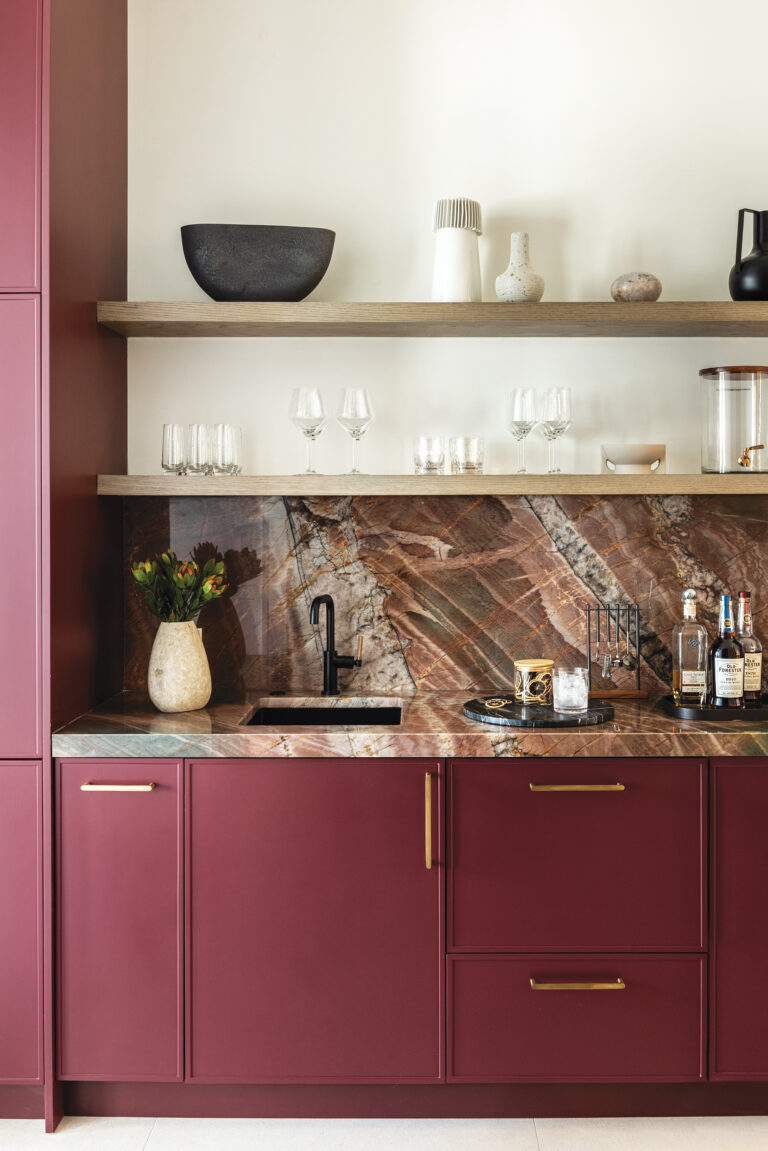 Dramatic quartzite slabs dictated the deep red color of the cabinetry in a statement-making butler’s pantry.