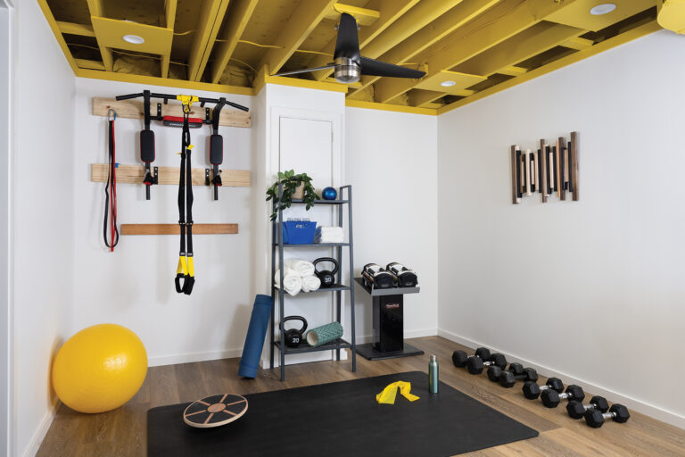 Hildebrandt added energy to a home gym with an exposed ceiling painted bold yellow that complements the training equipment.