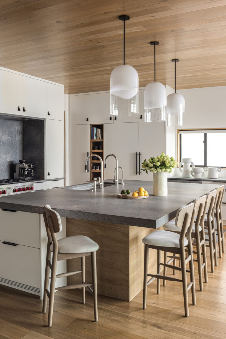In an airy, contemporary kitchen, oversized pendants from Articolo Studios and Future Perfect stools bring a design-forward edge to the spacious island.