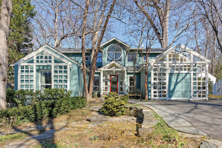 A whole-house renovation and additions reimagined a home’s front façade with a covered front entry and latticework in a grid.