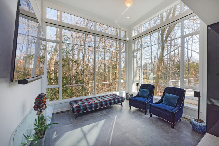 A clever design cantilevered a rear-facing, glassed-in space above its sloped, wooded site.