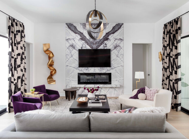 Swirling Calacatta Viola marble slabs frame the living room fireplace in a newly built home; Pierre Frey drapery adds geometry. Styling: Walker Wright.
