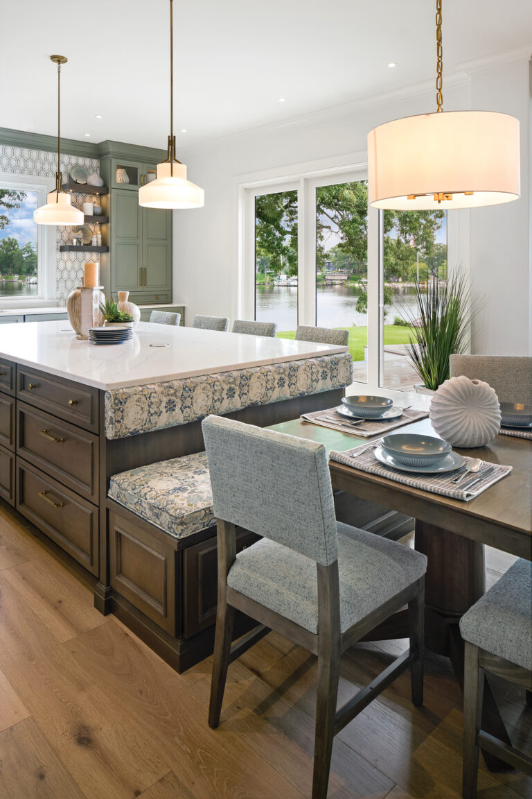 A walnut island incorporates bench seating for an adjacent table in matching wood tones; textured fabrics complement the soft palette.