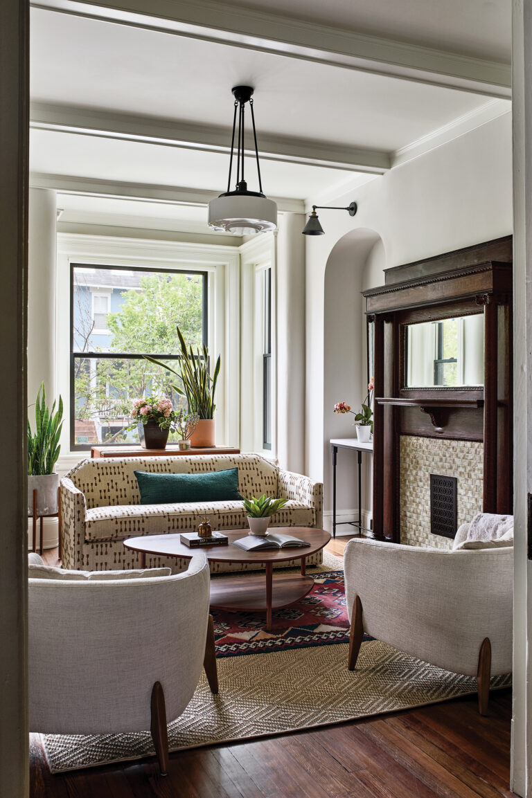 The living room of a Victorian row house in DC showcases original details enhanced with a new coffered ceiling, arched art niches and decorative lighting.