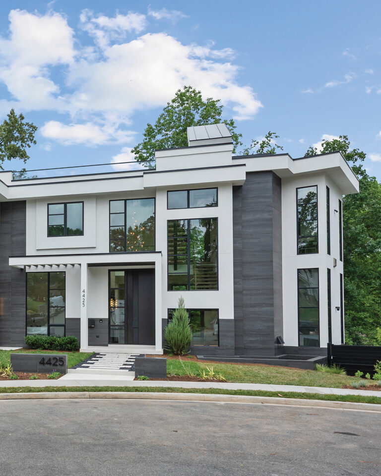 A modern infill custom home in Arlington is clad in stucco and porcelain tile, punctuated by panels of glass.