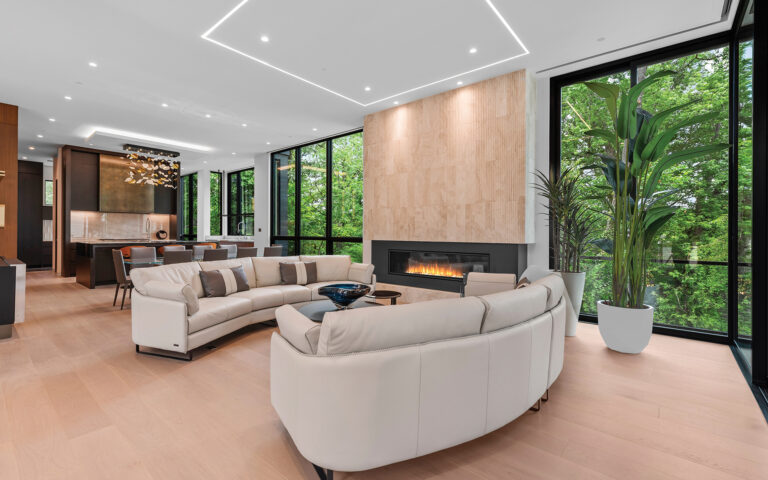 Because the lot drops steeply in back, the home’s open living spaces, with their 11-foot ceilings and floor-to-ceiling window walls, create the feel of treetop living.