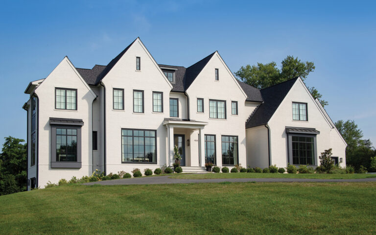 A custom home in Potomac balances scale and proportion with banks of windows facing front.