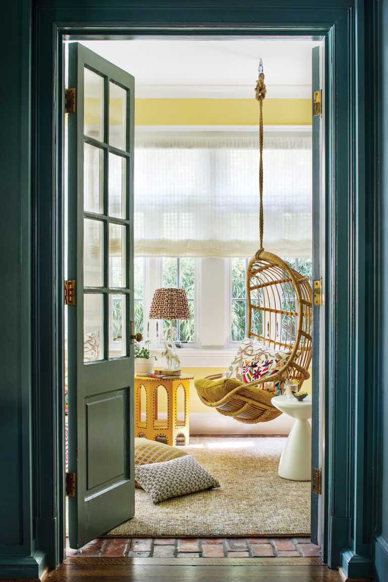 In an airy sunroom, a bank of windows brings the outdoors in.