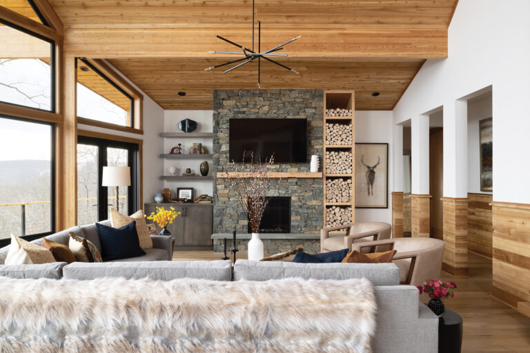 In a Blue Ridge getaway, a contemporary-style fireplace wall of stone and wood complements the mountain views.
